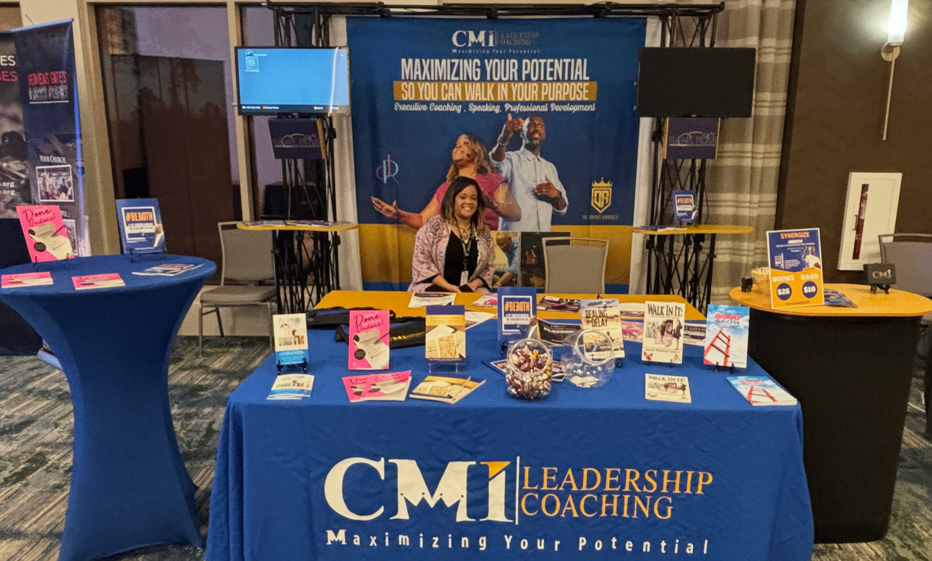 CMI Leadership Coaching booth displaying published books at a live event